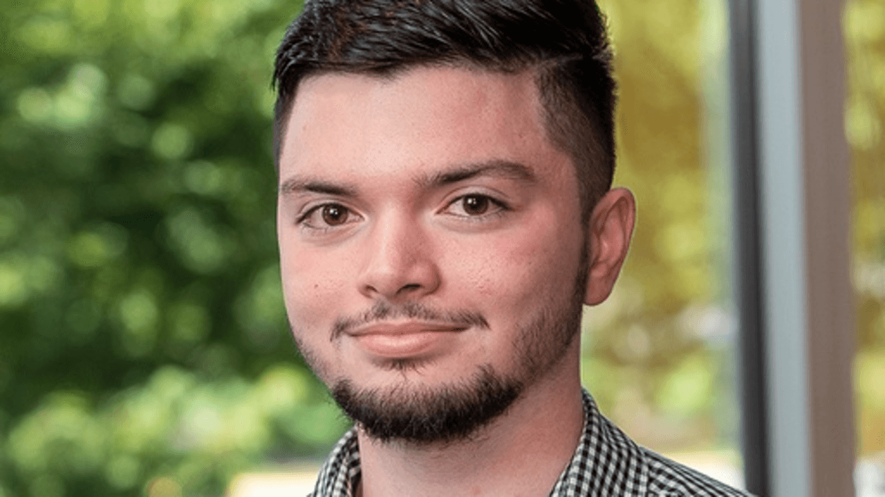 A headshot of Mohib Rizvi smiling in front of a window.