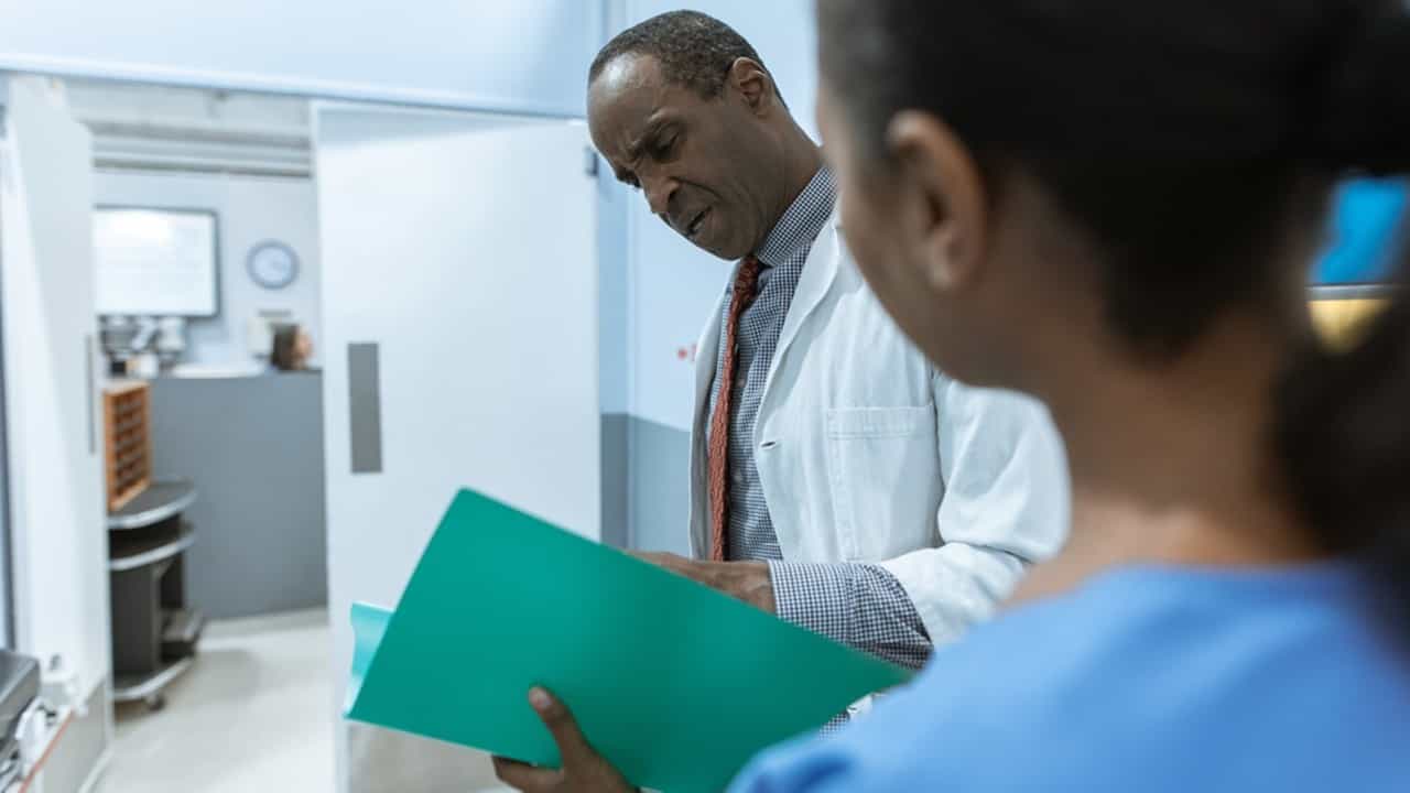 A photo of a Black doctor and Black patient.