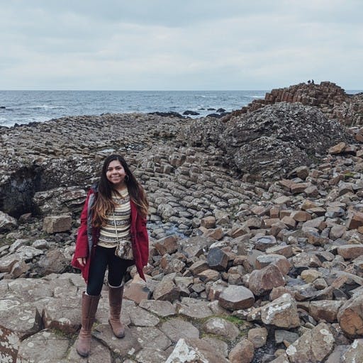A photo of Vanessa Berruetta standing on a rocky beach.