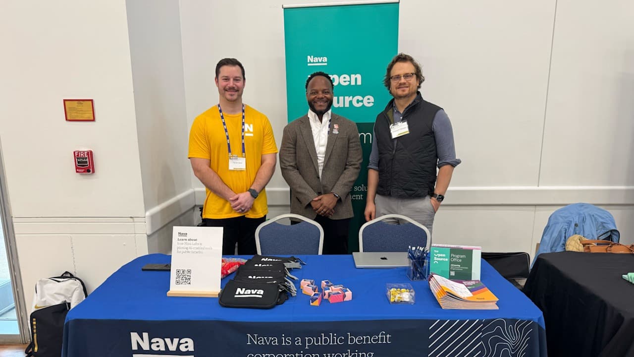 Three men stand at a Nava conference booth.