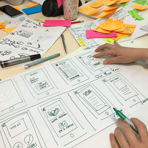 Person sketching wireframes at a table.
