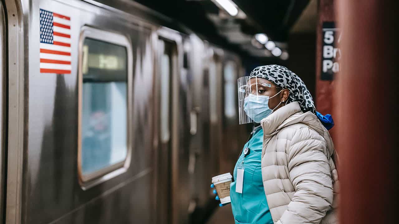 Health worker with face mask and shield in subway