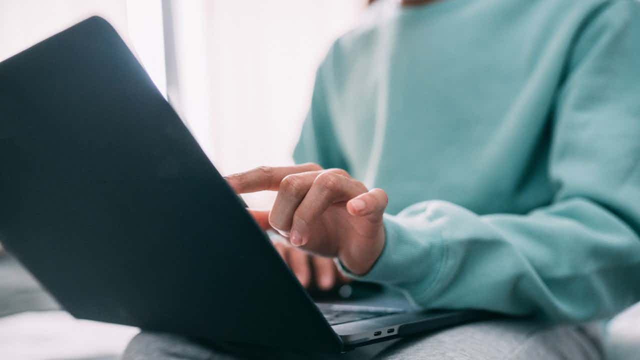 A white woman uses a laptop.