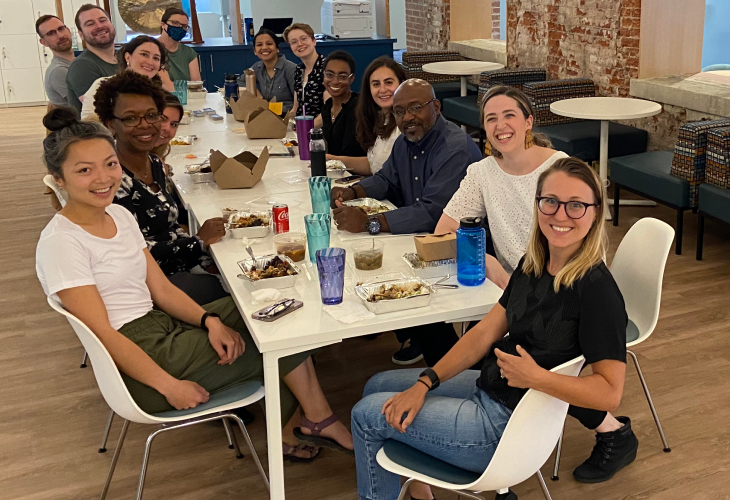 A diverse group of Nava employees eat lunch in the Washington D.C. office kitchen.